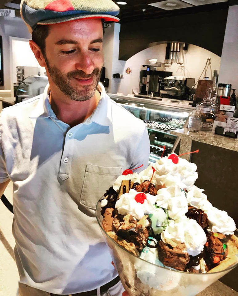 A man at The Percantile and Creamery, holding a giant bowl of ice cream for a birthday party